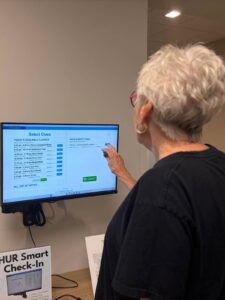 Plymouth Place resident using HUR Smart Check-In to select a fitness class